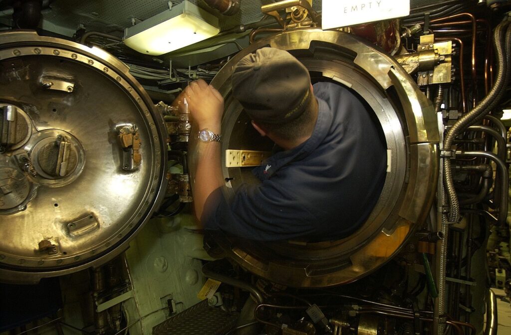 Submariner climbing into a torpedo tube. The tube is one of many constraints that the operator has to deal with.