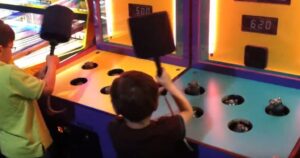 Two kids competing at whack a mole