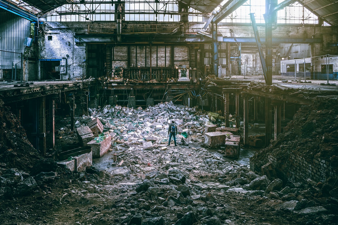 Man standing in a damaged factory. Looking at the seven wastes but not knowing where to start